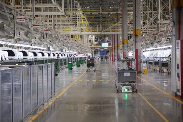自動(dòng)化牽引小車穿行在北汽株洲基地二工廠的總裝車間里。